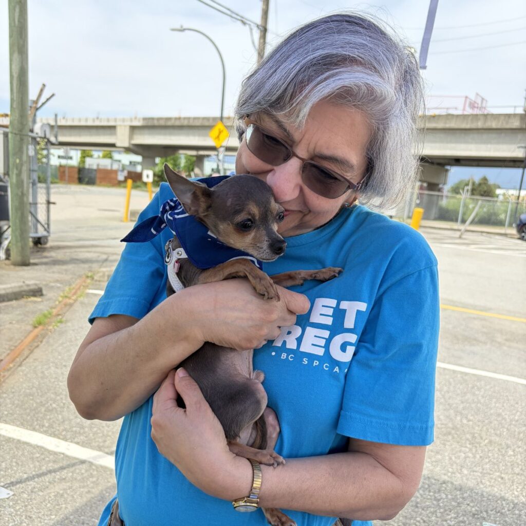 senior pet guardian holding a dog